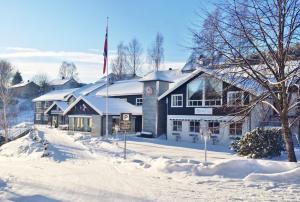 a large building with a flag in the snow at Kongsberg Hostel-Vandrerhjem in Kongsberg