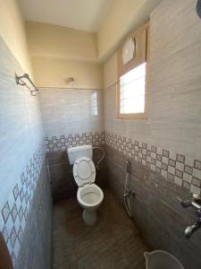 a bathroom with a toilet and a sink at Hotel Renuka in Visakhapatnam