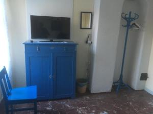 un armario azul con un televisor encima en Brunnsta Gård en Bålsta