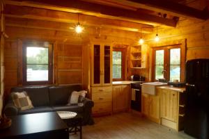 a living room with a couch and a kitchen at Smolnikowe Klimaty - Chyżula - Sauna&Jacuzzi in Komańcza