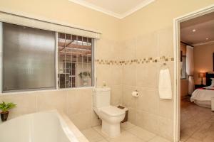 uma casa de banho com um WC e uma banheira em Chartwell Guest House em Durban