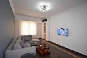 a living room with a couch and a tv on a wall at Buzand street 1 bedroom Newly Renovated apartment near Republic Square BU777 in Yerevan