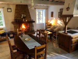 a living room with a table and a fireplace at Gîte La Maison d'Amélie in La Chapelle-Saint-Aubert +26 photos