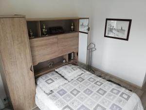 um quarto com uma cama e uma cabeceira em madeira em Le Courtois em Saint Malo