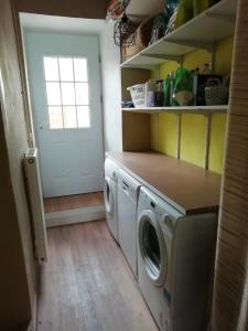 eine Waschküche mit Waschmaschine und Trockner in der Unterkunft Les Bories en Champagne in Montlevon