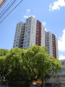 un edificio alto con árboles delante de él en Apê 104-B Confortável no Centro, en Foz do Iguaçu