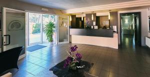 a lobby with purple flowers on a tile floor at Bolgheri Marina Resort in Marina di Bibbona