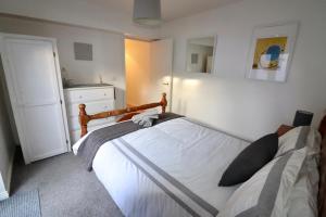 a bedroom with a bed with white sheets and a mirror at Clifton Park in Belfast