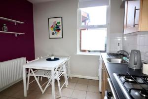a kitchen with a white table and chairs in it at Clifton Park in Belfast