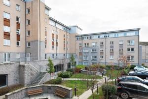 un grupo de edificios con coches estacionados en un estacionamiento en City Centre Orange Apartments - Portland Street, en Aberdeen