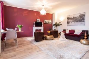 sala de estar con pared roja y sofá en E&K Apartment Elberfeld, en Wuppertal