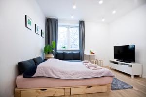 a bedroom with a bed and a flat screen tv at Studio Gaba 2 INTRACO Apartment in Warsaw