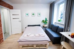 a small bedroom with a bed and a blue couch at Studio Gaba 2 INTRACO Apartment in Warsaw