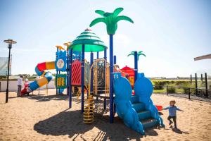 a child is standing in front of a playground at EuroParcs Parc du Soleil in Noordwijk aan Zee