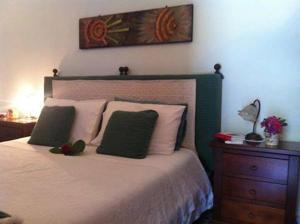 una camera con un letto con due cuscini verdi di Sa Corte Nova a Lula