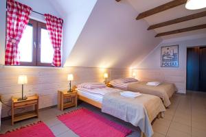 two beds in a room with two windows at Malowane Wierchy in Gładyszów