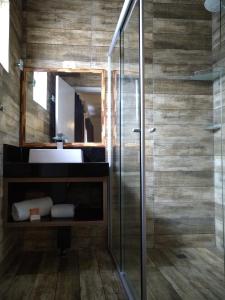 a bathroom with a glass shower and a sink at Medieval Hotel in Três Corações