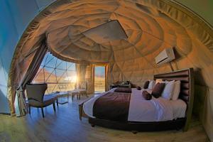 una camera con letto in una stanza a forma di cupola di Wadi Rum UFO Luxotel a Wadi Rum