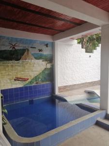 einen Pool in einem Haus mit einem Gemälde an der Wand in der Unterkunft Brisas del Magdalena in La Dorada