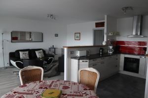 een keuken en een woonkamer met een tafel en stoelen bij Le Courtois in Saint-Malo
