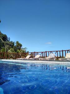 uma piscina com o oceano ao fundo em Pousada Ilha do Meio em Itacimirim