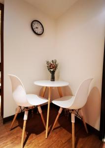 HualingにあるCasa Enteraのテーブルと椅子2脚、壁掛け時計