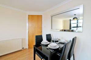 a dining room with a black table and black chairs at OrangeApartments Riverside Drive,5 Minutes from City Centre in Aberdeen