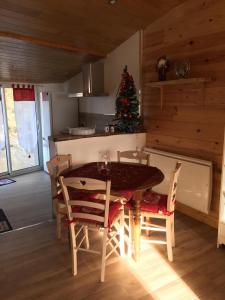 a kitchen with a table and chairs and a christmas tree at logement paisible à la campagne (2 à 4 personnes) in Aubarède