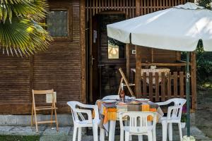 カヴァッリーノ・トレポルティにあるAppartamenti & Bungalows Luca Angiolinの家の前の傘付きテーブル