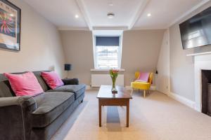 a living room with a couch and a table at Stunning & Central Milsom Street Apartment in Bath