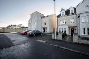 a car parked in a parking lot next to buildings at Orange Apartments Polmuir Gardens Only 7 minutes to City Centre in Aberdeen