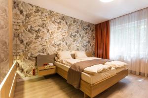 um quarto com uma cama com papel de parede floral em SCA Sofia City Apartments em Sófia