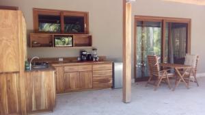 uma cozinha com armários de madeira e uma mesa e cadeiras em Casa Papito em Potrero