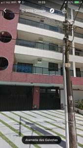 a street sign in front of a building at Apartamento com área externa na Bacutia - uma quadra do mar in Guarapari