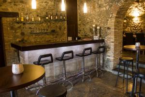 a bar with stools and tables in a restaurant at Masia d'Amer - Complex rural amb encant in Amer