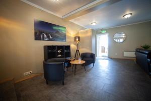 een woonkamer met banken en een tafel en stoelen bij Kirkjufell Hotel by Snæfellsnes Peninsula West Iceland - Grundarfjordur in Grundarfjordur