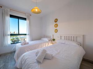 2 bedden in een witte kamer met een raam bij PALM BEACH APARTMENT - Torremolinos in Torremolinos