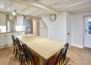 a wooden table in a kitchen with a clock on the wall at Host & Stay - Middle Farmhouse in Whitby +10 photos