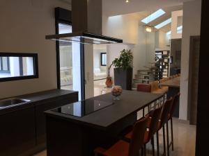 une cuisine avec un îlot doté d'un comptoir et de chaises dans l'établissement VILLA OCEANE, à Cannes