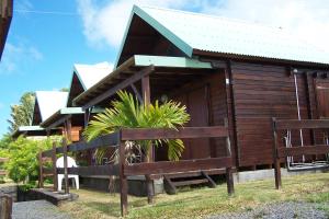 eine Holzhütte mit einem Zaun davor in der Unterkunft Les Vanilliers Location BUNGALOWS in Saint-Joseph