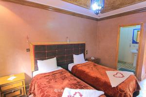 Habitación de hotel con 2 camas y espejo en Gite Ghazal - Atlas Mountains Hotel en Imlil