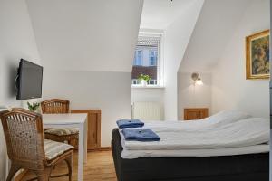 Sweethome Guesthouse في إيسبيرغ: غرفة نوم صغيرة مع سرير ومكتب