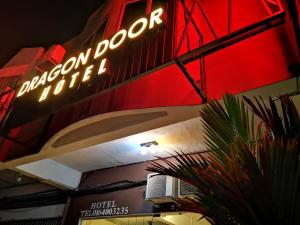 a neon sign hanging from the side of a restaurant at Dragon Door Hotel in Sitiawan