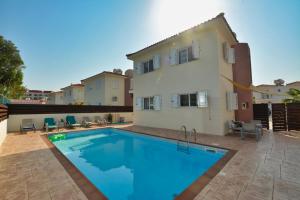a swimming pool in front of a house at Anasta villa in Protaras