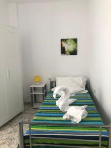 1 dormitorio con 1 cama con toallas en Costa Las Maretas, en Lomo de Arico