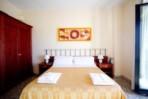 ein Schlafzimmer mit einem großen Bett mit zwei Handtüchern darauf in der Unterkunft Hotel Don Pedro in Portoscuso