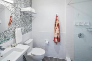 a bathroom with a white toilet and a sink at The Longleaf Hotel in Raleigh