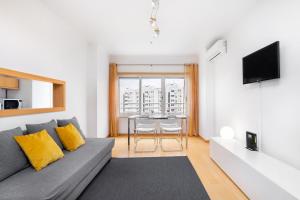 a living room with a couch and a table at Lisboa, Cidade, Elegant Apartment with Air Cond, Free WIFI and Near Metro, by IG in Lisbon