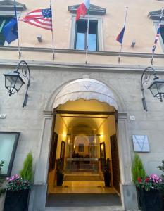 een toegang tot een gebouw met vlaggen erop bij Vogue Hotel Arezzo in Arezzo