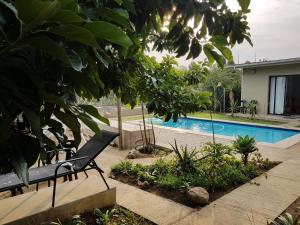 a swimming pool in a yard with a black bench at Veki's Town Lodge in Mbabane